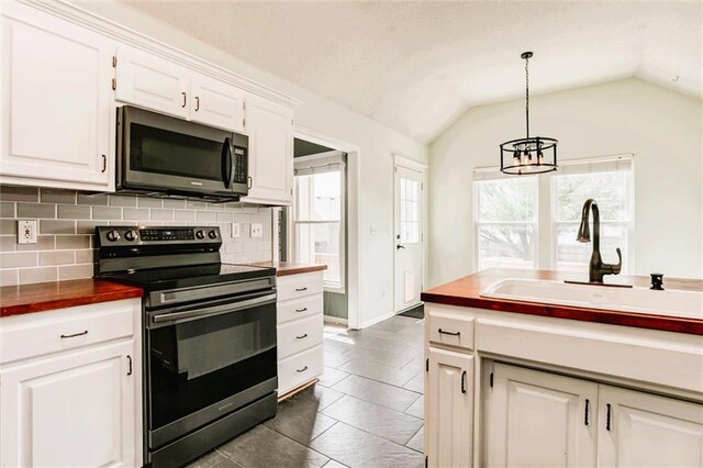 1039 Woodson Cir, Gardner, KS 66030 - kitchen featuring appliances with stainless steel finishes, wooden counters, decorative backsplash, healthy amount of natural light, and vaulted ceiling