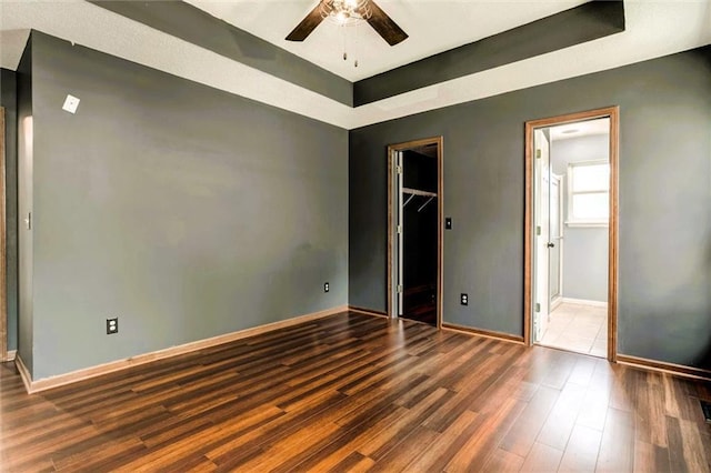 1039 Woodson Cir, Gardner, KS 66030 - unfurnished bedroom with wood finished floors, a walk in closet, a closet, and connected bathroom