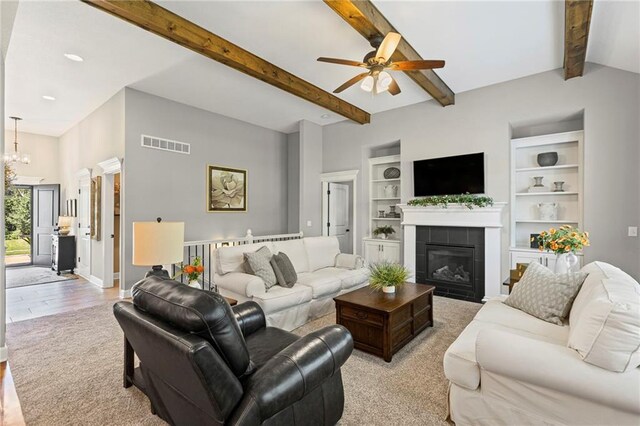801 155th Ter, Basehor, KS 66007 - living room with a ceiling fan, a fireplace, light wood finished floors, built in features, and beam ceiling