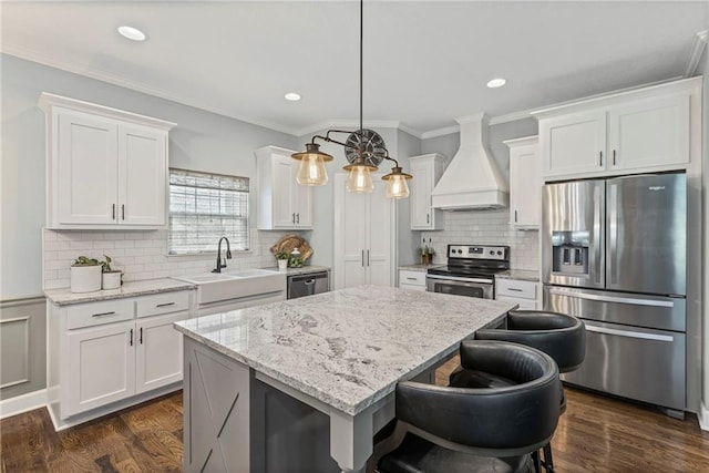 801 155th Ter, Basehor, KS 66007 - kitchen featuring appliances with stainless steel finishes, custom exhaust hood, a center island, white cabinetry, and decorative backsplash