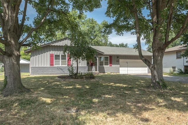 1222 S Maple St, Ottawa, KS 66067 - ranch-style house featuring board and batten siding, asphalt driveway, an attached garage, brick siding, and a front lawn