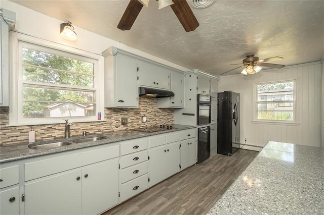 1222 S Maple St, Ottawa, KS 66067 - kitchen with a ceiling fan, black appliances, under cabinet range hood, backsplash, and dark wood-type flooring