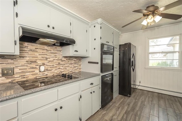 1222 S Maple St, Ottawa, KS 66067 - kitchen with under cabinet range hood, black appliances, wood finished floors, tasteful backsplash, and ceiling fan