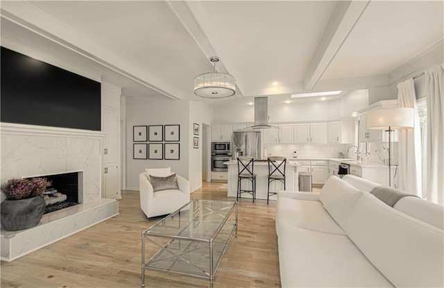 12600 Mohawk Ln, Leawood, KS 66209 - living area featuring light wood-type flooring, beam ceiling, and a premium fireplace