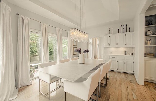 12600 Mohawk Ln, Leawood, KS 66209 - dining space featuring a raised ceiling, a chandelier, and light wood-style flooring