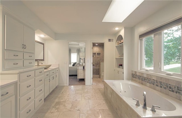 12600 Mohawk Ln, Leawood, KS 66209 - full bath featuring a jetted tub, connected bathroom, vanity, stone tile floors, and recessed lighting