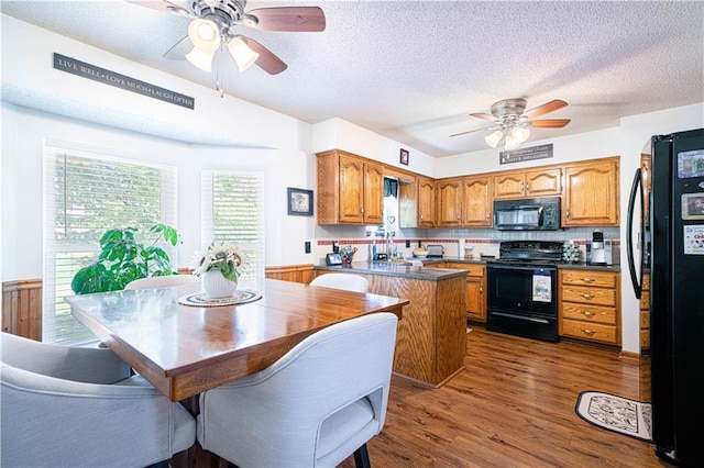 203 Scout St, Camden Point, MO 64018 - kitchen with black appliances, a ceiling fan, brown cabinets, a peninsula, and dark countertops