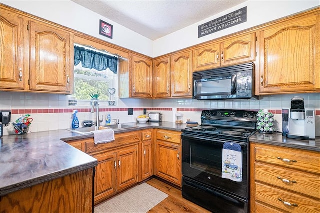 203 Scout St, Camden Point, MO 64018 - kitchen featuring black appliances, brown cabinets, and a textured ceiling