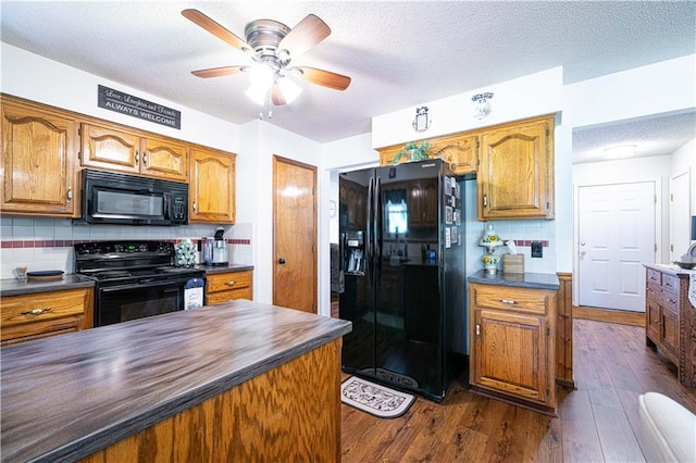 203 Scout St, Camden Point, MO 64018 - kitchen featuring black appliances, dark countertops, ceiling fan, dark wood-style floors, and backsplash