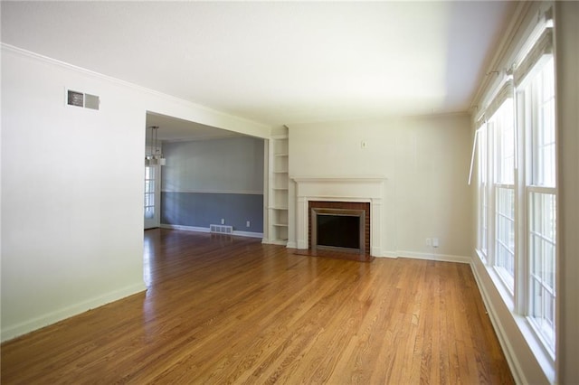 7236 Roe Ave, Prairie Village, KS 66208 - unfurnished living room with wood finished floors, a brick fireplace, and ornamental molding