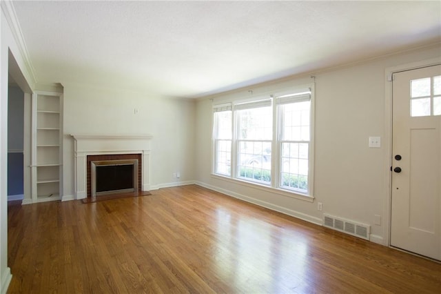 7236 Roe Ave, Prairie Village, KS 66208 - unfurnished living room with wood finished floors, a fireplace, ornamental molding, and built in shelves