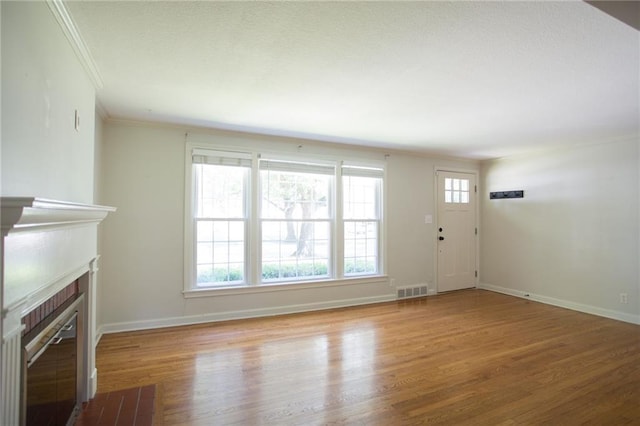 7236 Roe Ave, Prairie Village, KS 66208 - unfurnished living room with wood finished floors, ornamental molding, and a fireplace with flush hearth