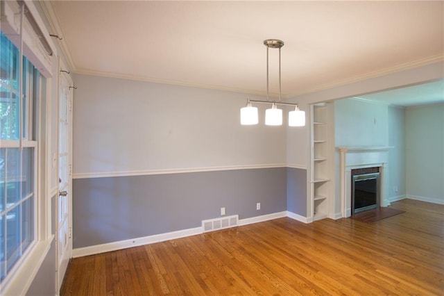 7236 Roe Ave, Prairie Village, KS 66208 - unfurnished living room with wood finished floors, ornamental molding, a fireplace, and built in shelves