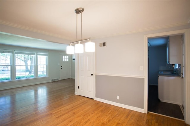 7236 Roe Ave, Prairie Village, KS 66208 - unfurnished dining area featuring light wood-type flooring and ornamental molding