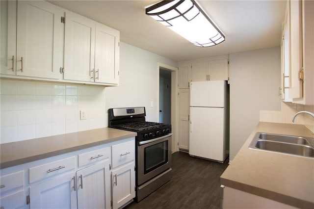 7236 Roe Ave, Prairie Village, KS 66208 - kitchen featuring freestanding refrigerator, stainless steel gas range oven, white cabinetry, decorative backsplash, and dark wood finished floors