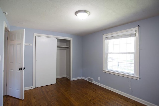 7236 Roe Ave, Prairie Village, KS 66208 - unfurnished bedroom with dark wood-style flooring, a closet, and a textured ceiling