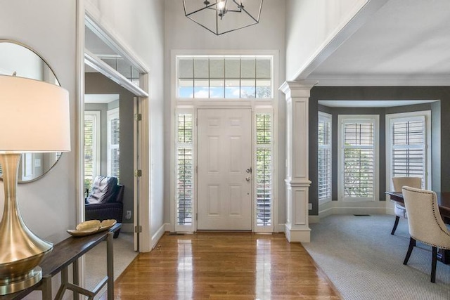 5125 W 164th St, Overland Park, KS 66085 - entryway featuring ornate columns, plenty of natural light, a towering ceiling, wood finished floors, and crown molding