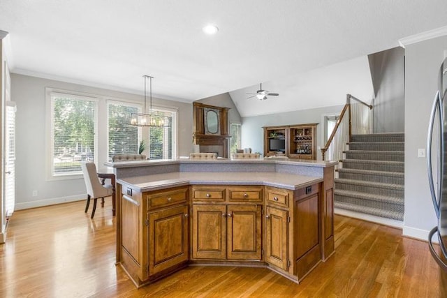 5125 W 164th St, Overland Park, KS 66085 - kitchen with brown cabinets, ceiling fan, light countertops, light wood-style floors, and crown molding
