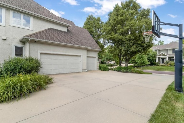 5125 W 164th St, Overland Park, KS 66085 - view of side of property featuring stucco siding, a shingled roof, concrete driveway, and a garage