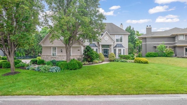 5125 W 164th St, Overland Park, KS 66085 - view of front of home with a front yard, stone siding, and a chimney