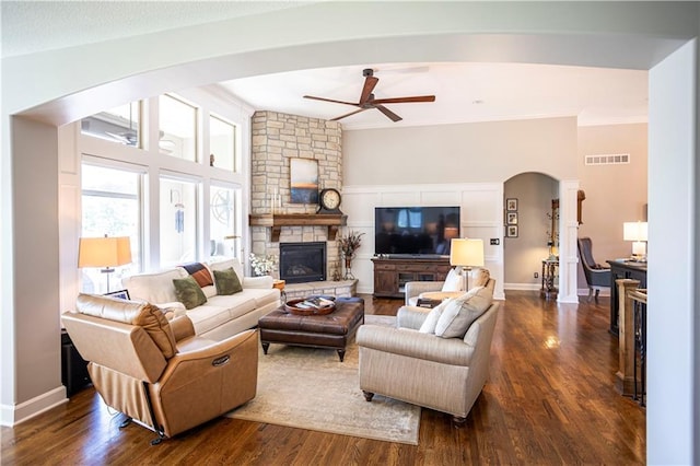 4500 Parks Summit Ter, Lees Summit, MO 64064 - living area featuring a fireplace, arched walkways, a ceiling fan, ornamental molding, and dark wood-style flooring
