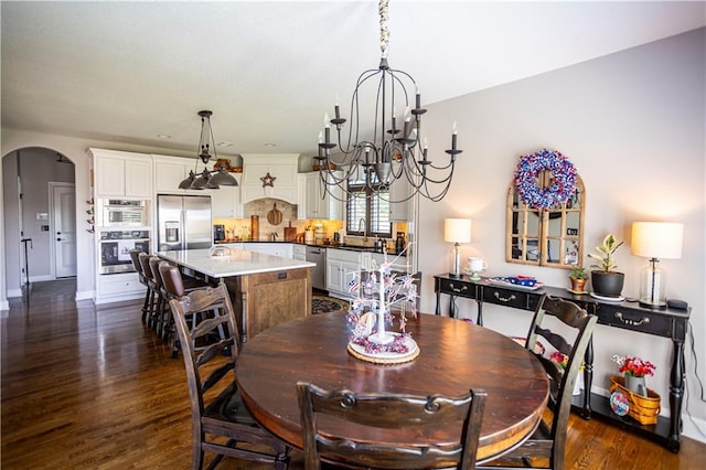 4500 Parks Summit Ter, Lees Summit, MO 64064 - dining area featuring a chandelier, arched walkways, and dark wood-type flooring
