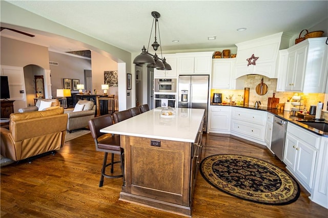 4500 Parks Summit Ter, Lees Summit, MO 64064 - kitchen featuring appliances with stainless steel finishes, a breakfast bar, arched walkways, and white cabinetry