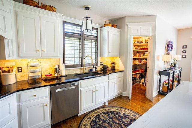 4500 Parks Summit Ter, Lees Summit, MO 64064 - kitchen featuring stainless steel dishwasher, white cabinetry, decorative backsplash, dark wood finished floors, and hanging light fixtures