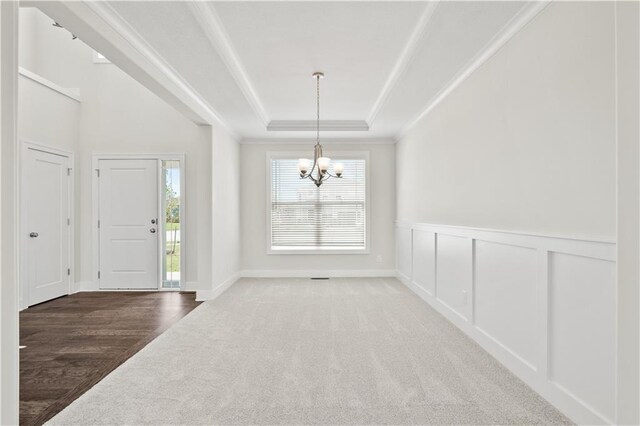 28400 W 161st Ter, Gardner, KS 66030 - carpeted foyer with a raised ceiling, a chandelier, ornamental molding, a wainscoted wall, and a decorative wall