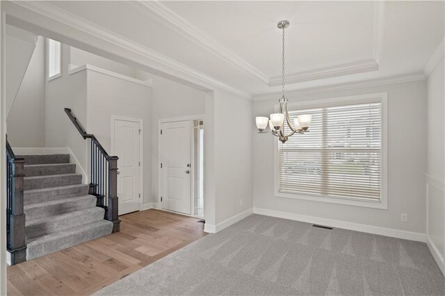 28501 W 161st Ter, Gardner, KS 66030 - foyer with a chandelier, stairs, crown molding, a raised ceiling, and carpet