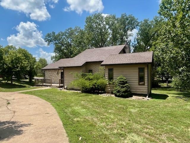 6960 Dancaster Rd, Topeka, KS 66610 - view of side of property with a yard, a wooden deck, and roof with shingles