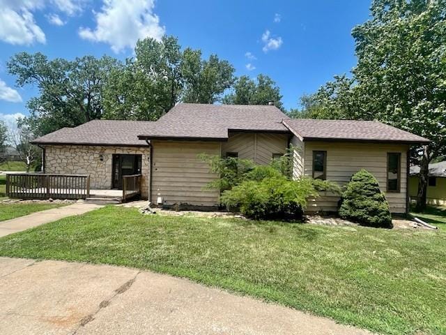 6960 Dancaster Rd, Topeka, KS 66610 - ranch-style home featuring a front lawn, a wooden deck, stone siding, and roof with shingles