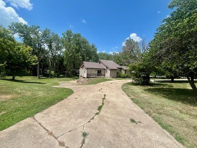 6960 Dancaster Rd, Topeka, KS 66610 - view of front of house featuring a front lawn, driveway, and view of scattered trees