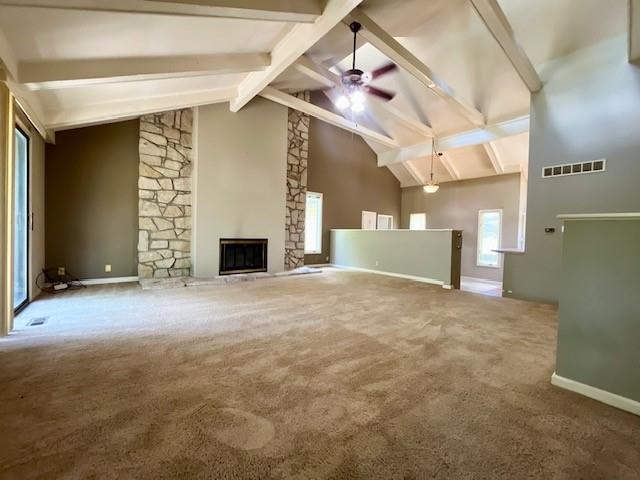 6960 Dancaster Rd, Topeka, KS 66610 - unfurnished living room with ceiling fan, high vaulted ceiling, a stone fireplace, carpet flooring, and beamed ceiling