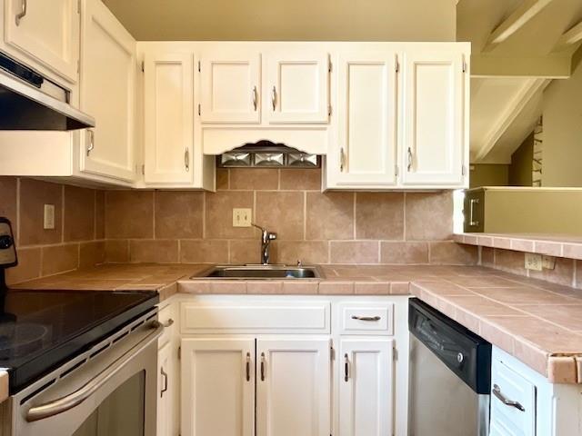 6960 Dancaster Rd, Topeka, KS 66610 - kitchen with appliances with stainless steel finishes, extractor fan, and tile countertops
