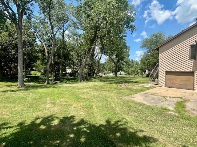 6960 Dancaster Rd, Topeka, KS 66610 - view of grassy yard featuring a garage, stairs, and driveway