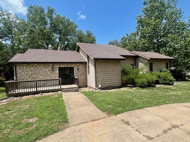 6960 Dancaster Rd, Topeka, KS 66610 - view of front facade featuring a front lawn, stone siding, and roof with shingles