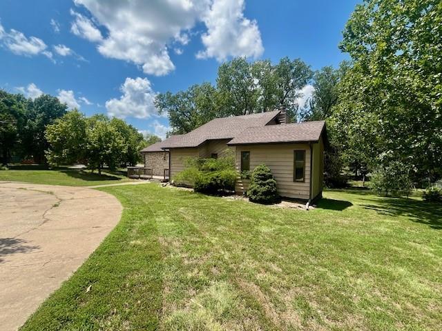 6960 Dancaster Rd, Topeka, KS 66610 - view of property exterior with a lawn and a chimney