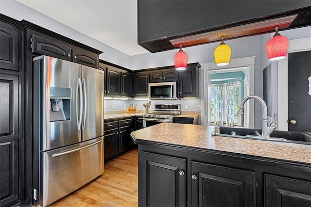 1148 N 1st Rd, Baldwin City, KS 66006 - kitchen featuring stainless steel appliances, light wood-style flooring, light countertops, and decorative light fixtures