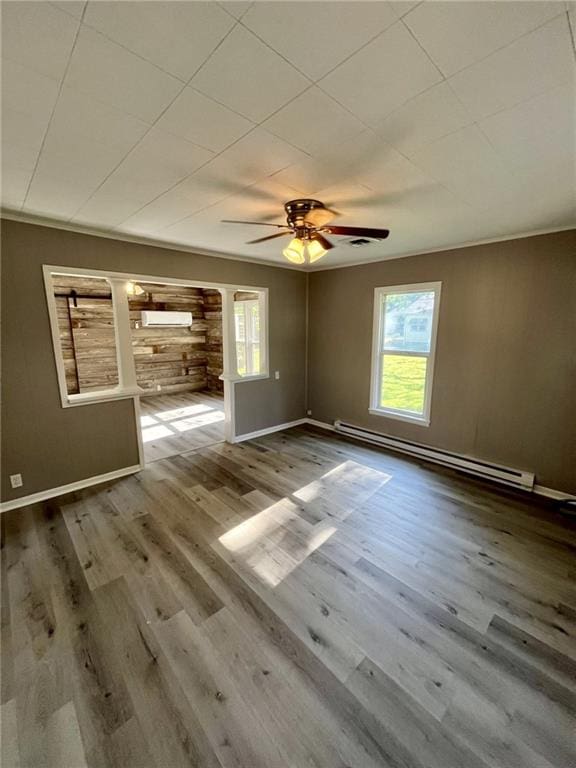 1629 E Oak St, Fort Scott, KS 66701 - empty room featuring a baseboard heating unit, plenty of natural light, decorative columns, and ceiling fan