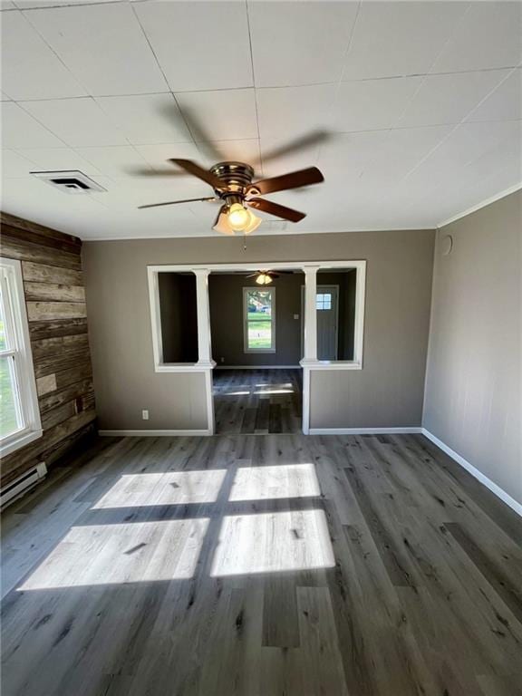 1629 E Oak St, Fort Scott, KS 66701 - unfurnished living room with wood walls, a ceiling fan, and wood finished floors