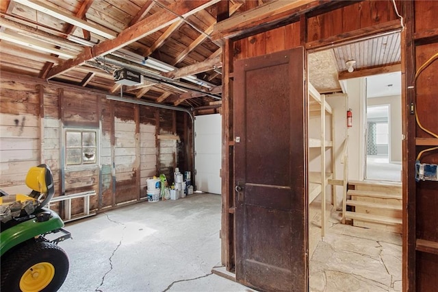 609 W Beech St, Independence, KS 67301 - garage featuring a garage door opener and wood walls
