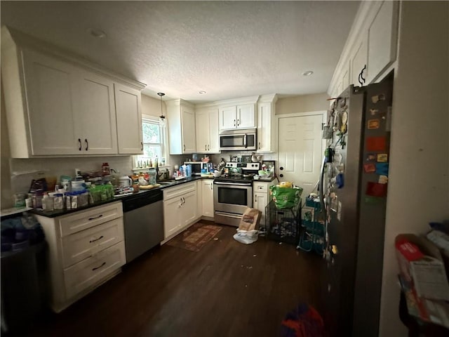 6212 Hadley St, Mission, KS 66202 - kitchen featuring stainless steel appliances, dark wood-type flooring, dark countertops, white cabinets, and a textured ceiling