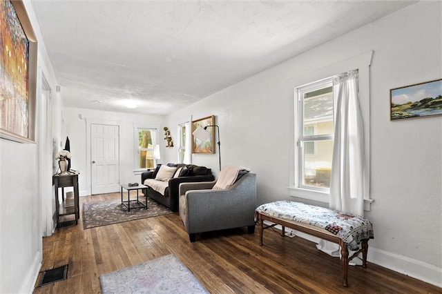 707 W 75th Ter, Kansas City, MO 64114 - living room featuring wood-type flooring, healthy amount of natural light, and a textured ceiling