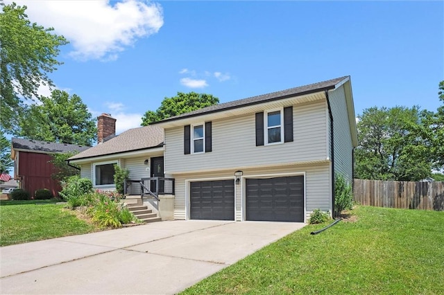 1108 W Pleasant Dr, Raymore, MO 64083 - tri-level home featuring concrete driveway, a chimney, and an attached garage
