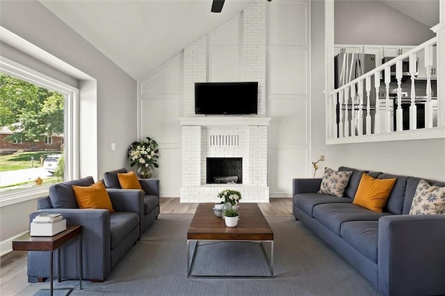 1108 W Pleasant Dr, Raymore, MO 64083 - living area featuring wood finished floors, a fireplace, and high vaulted ceiling