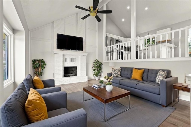 1108 W Pleasant Dr, Raymore, MO 64083 - living room with wood finished floors, ceiling fan, high vaulted ceiling, a fireplace, and recessed lighting