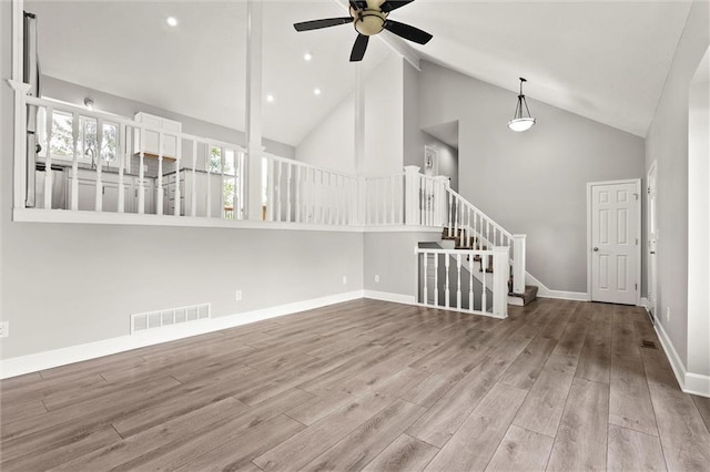 1108 W Pleasant Dr, Raymore, MO 64083 - spare room featuring high vaulted ceiling, a ceiling fan, wood finished floors, stairway, and recessed lighting