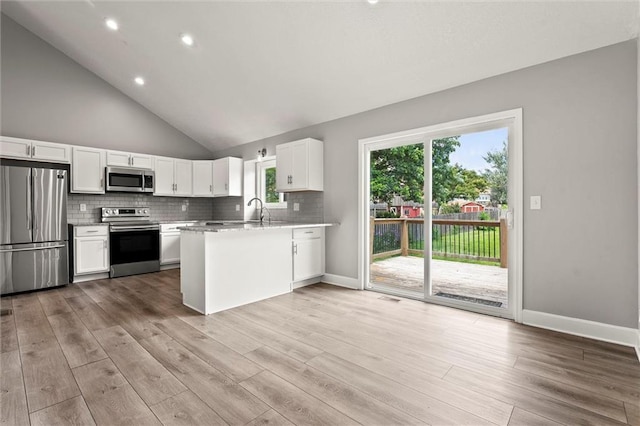 1108 W Pleasant Dr, Raymore, MO 64083 - kitchen featuring stainless steel appliances, a peninsula, white cabinets, light wood finished floors, and light countertops