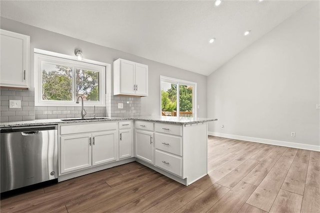 1108 W Pleasant Dr, Raymore, MO 64083 - kitchen with dishwasher, a peninsula, white cabinets, wood finished floors, and backsplash